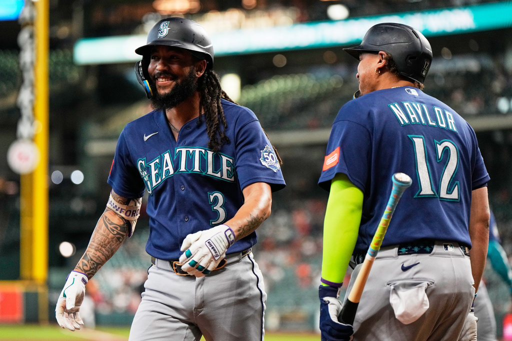 Seattle Mariners' J.P. Crawford (3) celebrates with Josh Naylor (12) after hitting a home run during the first inning of a baseball game against the Houston Astros in Houston, Wednesday, May 13, 2026. (AP Photo/Ashley Landis)