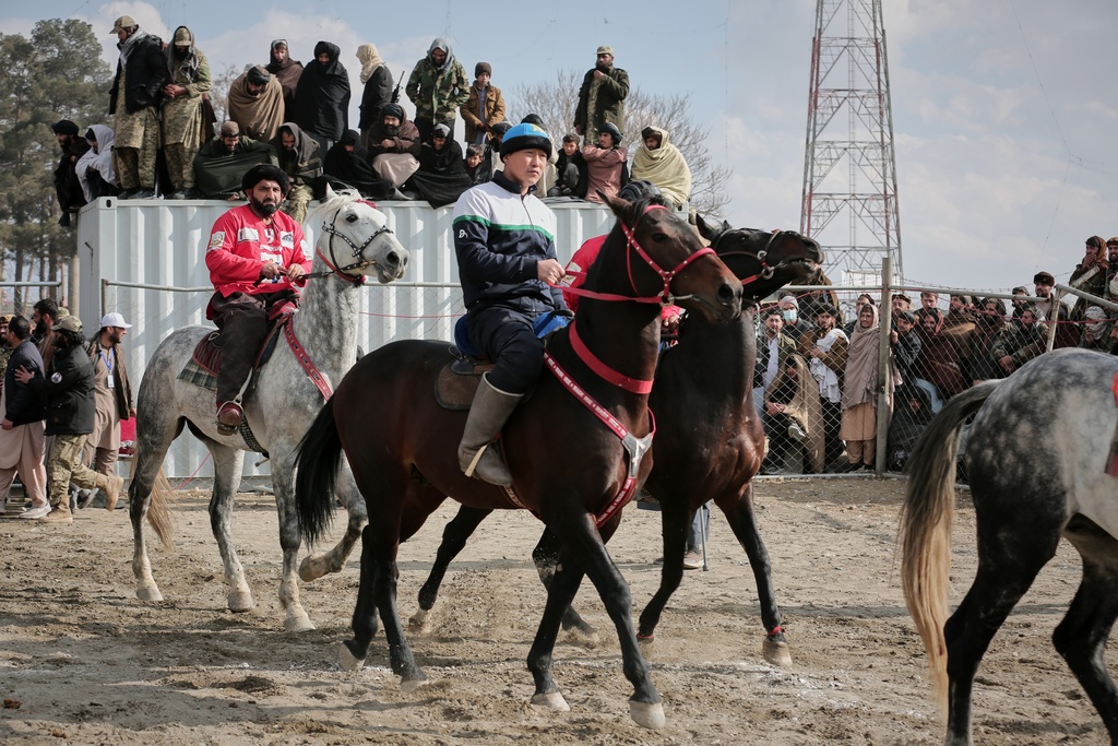 Riders from the Sar-e-Pul and Badakhshan teams enter the field to compete in the final of Afghanistan's annual buzkashi tournament, a traditional equestrian sport in which riders score points using a fake goat carcass, on the outskirts of Kabul, Afghanistan, Monday, Dec. 22, 2025. (AP Photo)