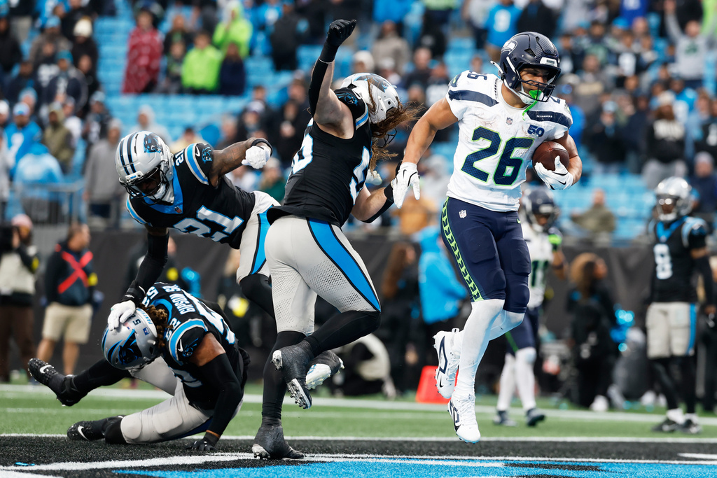 Seattle Seahawks running back Zach Charbonnet scores against the Carolina Panthers during the second half of an NFL football game, Sunday, Dec. 28, 2025, in Charlotte, N.C. (AP Photo/Rusty Jones)
