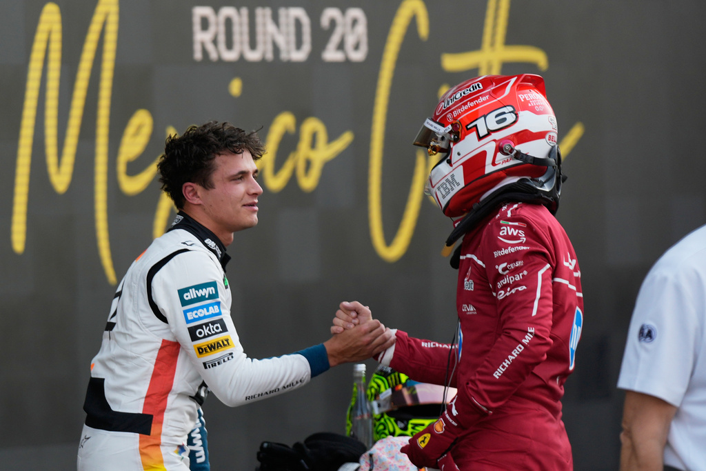McLaren driver Lando Norris of Britain, left, the pole position winner, is congratulated by Ferrari driver Charles Leclerc of Monaco, who qualified second, during the qualifying session for Formula One Mexico Grand Prix auto race at the Hermanos Rodriguez race track in Mexico City, Saturday, Oct. 25, 2025. (AP Photo/Fernando Llano)