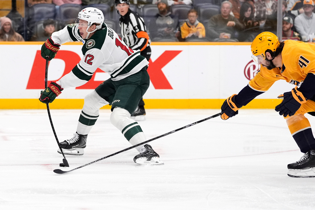 Minnesota Wild left wing Matt Boldy (12) shoots the puck to score a goal past Nashville Predators defenseman Nicolas Hague (41) during the first period of an NHL hockey game Wednesday, Feb. 4, 2026, in Nashville, Tenn. (AP Photo/George Walker IV)