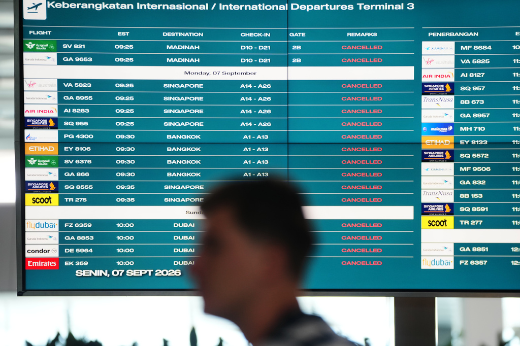 A man walks past an information board showing cancelled flights due to the eruption of Mount Anak Krakatau, at Soekarno-Hatta International Airport in Tangerang, Indonesia, Monday, Sept. 7, 2026. (AP Photo/Tatan Syuflana)
