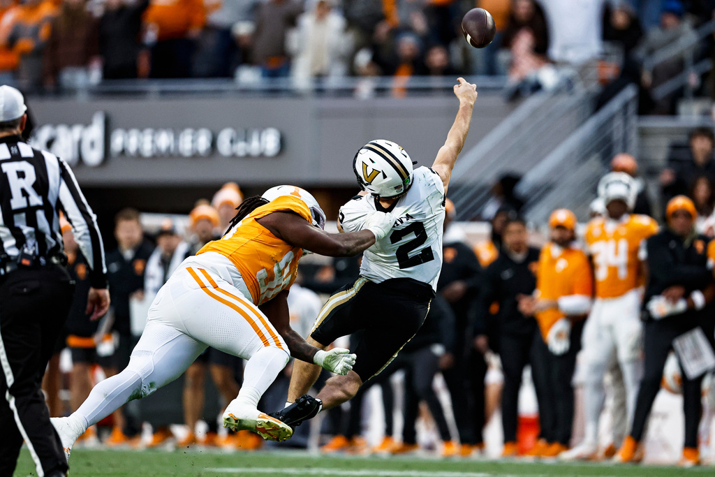 Vanderbilt quarterback Diego Pavia (2) throws as he is hit by Tennessee defensive lineman Dominic Bailey (90) during the first half of an NCAA college football game Saturday, Nov. 29, 2025, in Knoxville, Tenn. (AP Photo/Wade Payne)