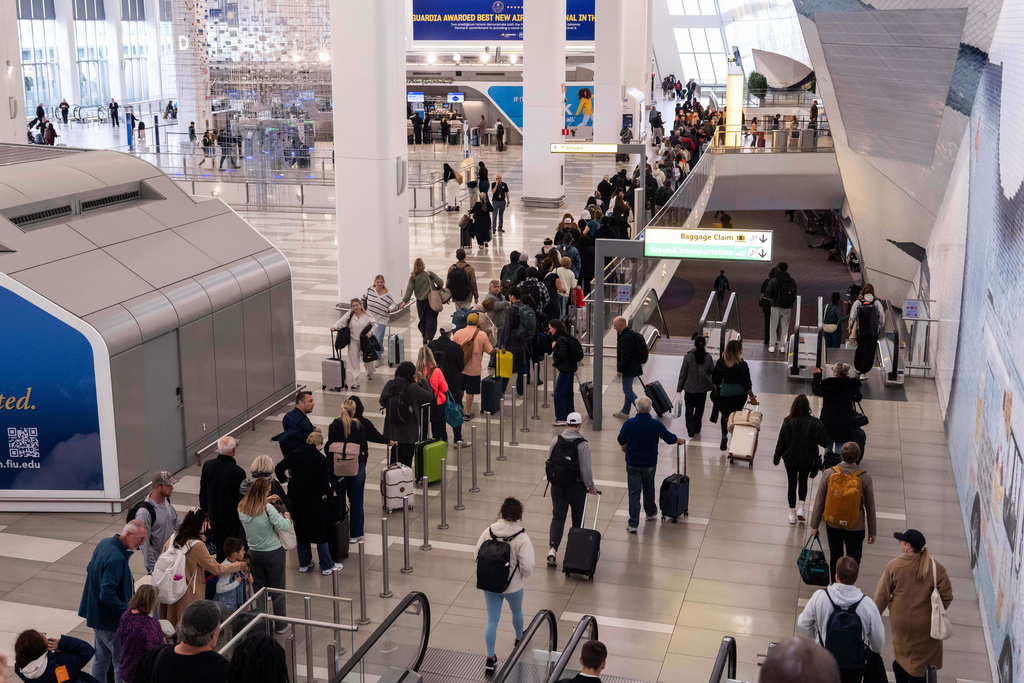 People wait in line at a Transportation Security Administration (TSA) security checkpoint at LaGuardia Airport (LGA) in the Queens borough of New York, Sunday, Nov. 9, 2025. (AP Photo/Adam Gray)