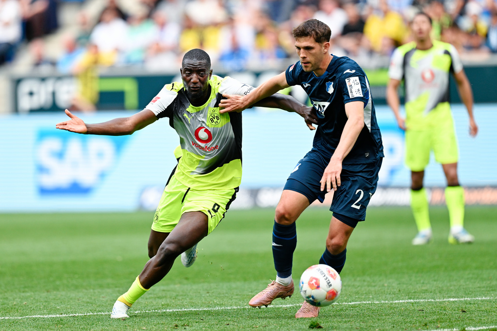 Dortmund's Serhou Guirassy, left, and Hoffenheim's Robin Hranac battle for the ball during their German Bundesliga soccer match in Sinsheim, Germany, Saturday, April 18, 2026. (Uwe Anspach/dpa via AP)