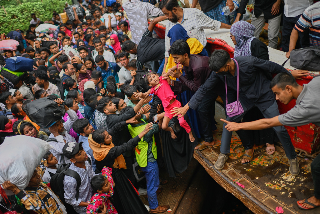 Thousands of travelers scramble and jostle each other to board ferries at the Sadarghat Launch Terminal, joining the massive annual exodus to celebrate Eid al-Fitr in their hometowns, in Dhaka, Bangladesh, Wednesday, March 18, 2026. (AP Photo/Mahmud Hossain Opu)