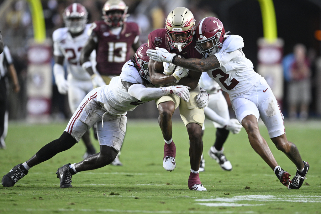 Florida State wide receiver Micahi Danzy, center, runs for yardage between Alabama linebacker Deontae Lawson (0) and defensive back Zabien Brown (2) during the second half of an NCAA college football game, Saturday, Aug. 30, 2025, in Tallahassee, Fla. (AP Photo/Phelan M. Ebenhack)