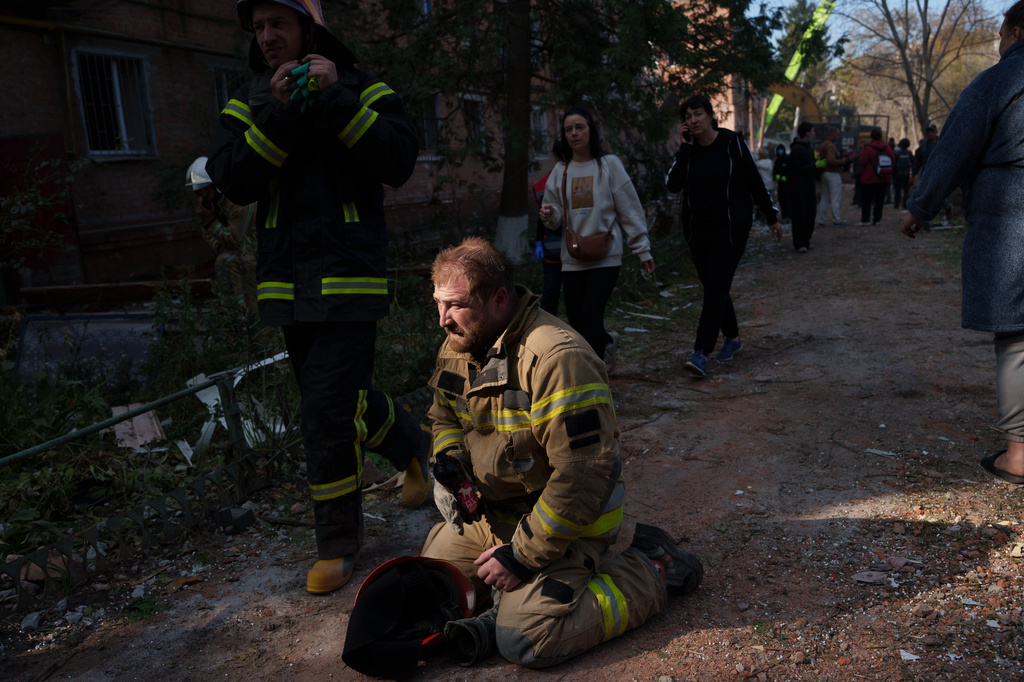 A rescue worker sits on the ground next to a residential building destroyed in a Russian missile strike on Pryluky, Ukraine, Wednesday, Oct. 7, 2026. (AP Photo/Evgeniy Maloletka)