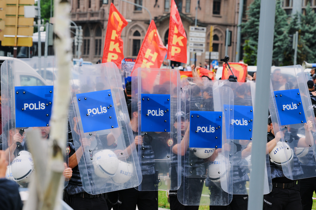 Police hold up their shields as protestors from the People's Liberation Party wave flags during a demonstration against the upcoming NATO Summit in Ankara, Turkey, Sunday, July 5, 2026. (AP Photo/Riza Ozel)