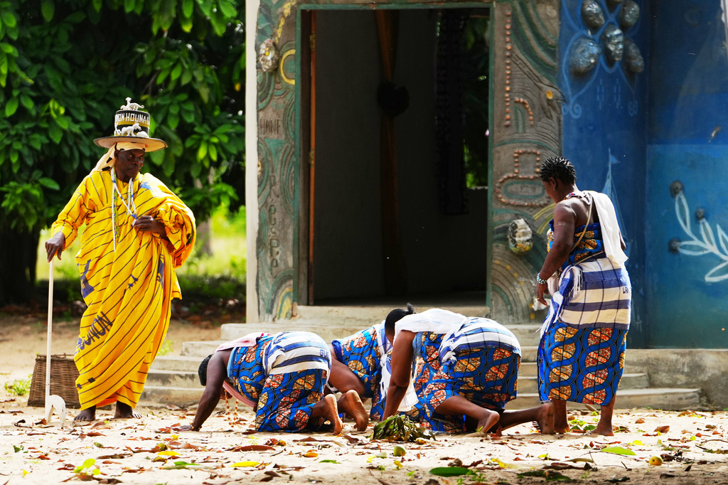 Daagbo Hounon Houna II, the Supreme Spiritual Voodoo Chief, left, is greeted by priestesses before an interview with The Associated Press In Ouidah, Benin, May 14, 2026. (AP Photo/Sunday Alamba)