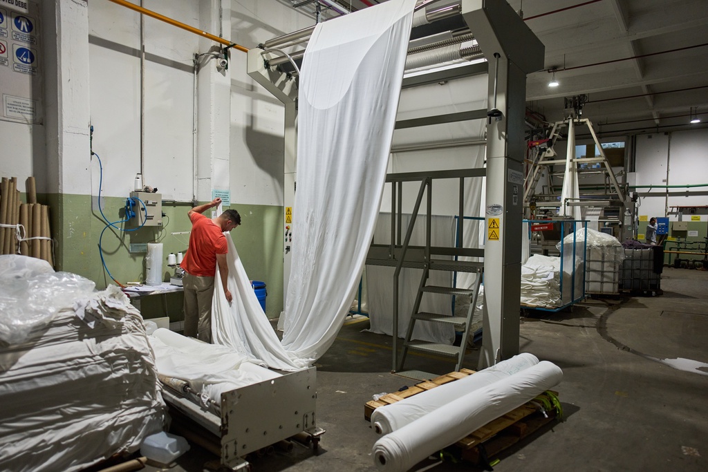 German Flores measures fabric at the Galfione Group textile factory in Buenos Aires, Argentina, Monday, Oct. 13, 2025. (AP Photo/Rodrigo Abd)