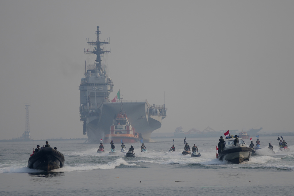 Indonesian Navy personnel escort the Giuseppe Garibaldi, a former Italian Navy aircraft carrier, center rear, as it arrives at Tanjung Priok port in Jakarta, Indonesia, Friday, Sept. 18, 2026. (AP Photo/Tatan Syuflana)