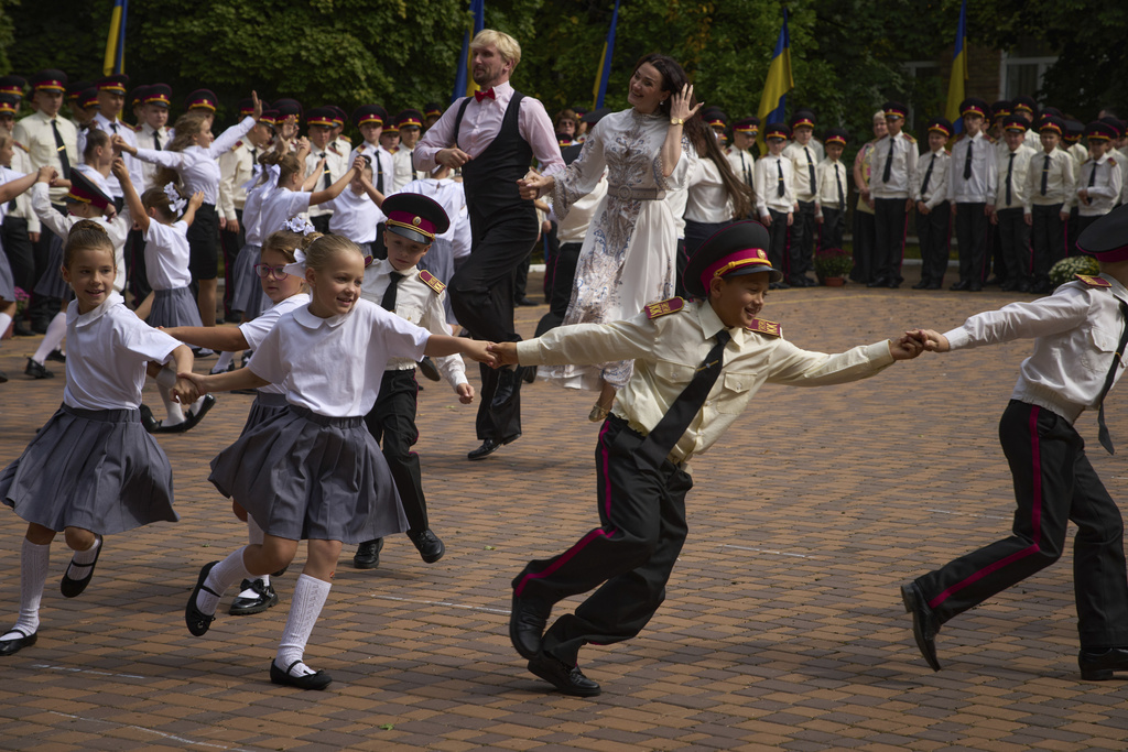 Schoolgirls and cadets dance as they attend a rehearsal of a ceremony on the first day at school at a cadet lyceum in Kyiv, Monday, Sept. 1, 2025. (AP Photo/Efrem Lukatsky)
