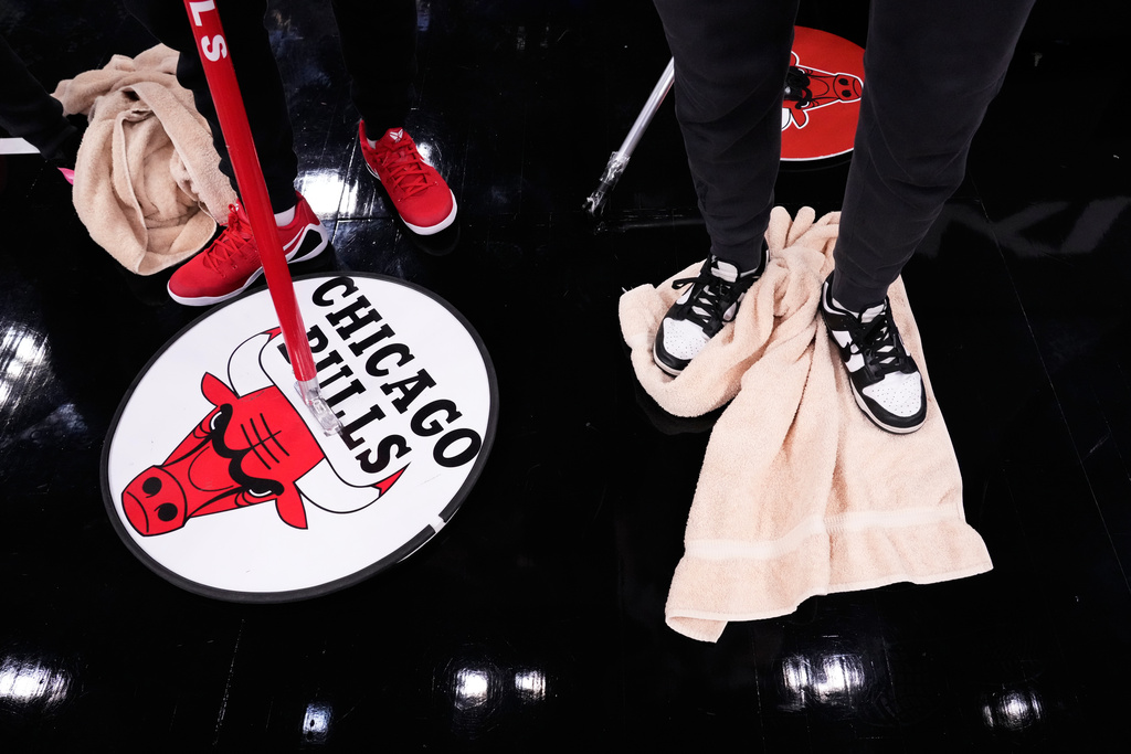 United Center employees try to dry the court before an NBA basketball game between the Miami Heat and the Chicago Bulls in Chicago, Thursday, Jan. 8, 2026. (AP Photo/Nam Y. Huh)