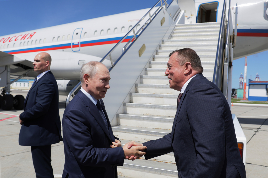 Russian President Vladimir Putin, second left, shakes hands with Sakhalin Region Governor Valery Limarenko at an airport in Kurilsk on the Iturup Island, the largest of the Kuril Islands of Russia's fareast, on Thursday, Aug. 13, 2026. (Gavriil Grigorov, Sputnik, Kremlin Pool Photo via AP)
