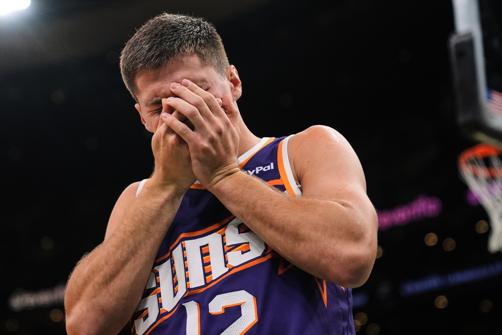 Phoenix Suns guard Collin Gillespie (12) reacts after getting hit in the face during the first half of an NBA basketball game against the Boston Celtics, Monday, March 16, 2026, in Boston. (AP Photo/Charles Krupa)
