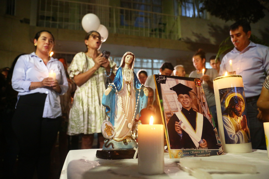 Friends and relatives hold a vigil for Johan Sebastián Durán Guerrero, a Colombian national who was fatally shot by an Immigration and Customs Enforcement officer in Maine, at his family home in Bucaramanga, Colombia, Tuesday, July 14, 2026. (AP Photo/Jaime Moreno)