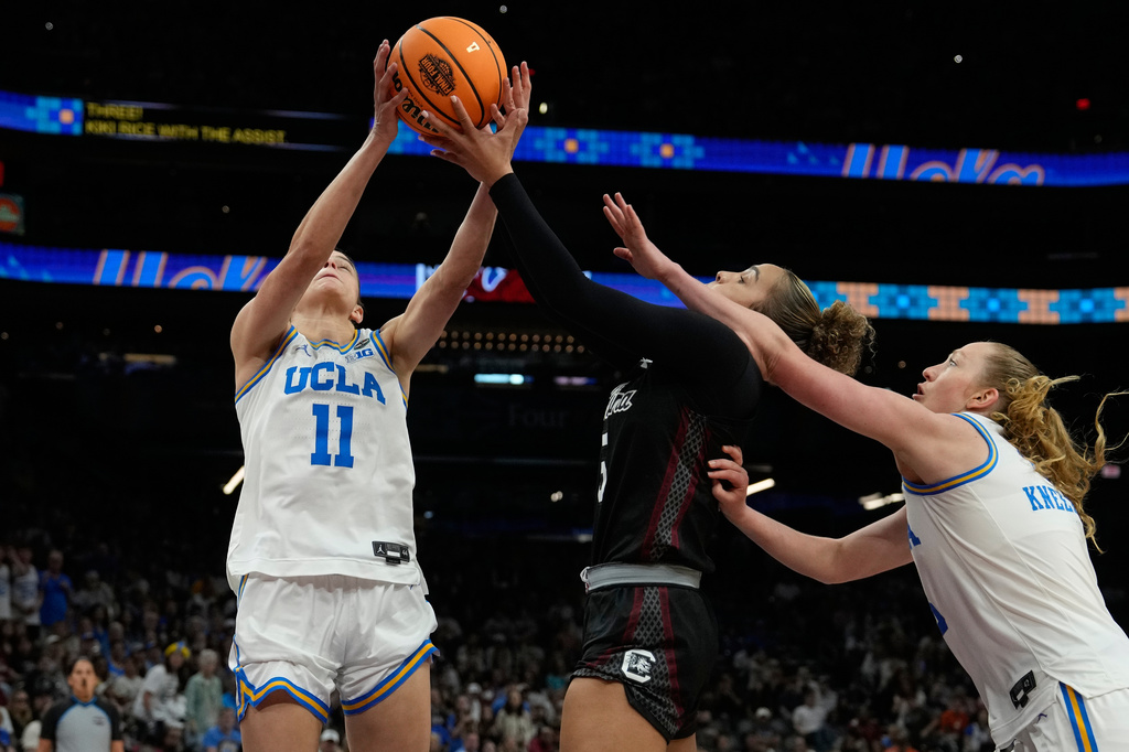 UCLA guard Gabriela Jaquez (11) grabs a rebound over South Carolina guard Tessa Johnson (5) during the second half of the women's National Championship Final Four NCAA college basketball tournament game, Sunday, April 5, 2026, in Phoenix. (AP Photo/Ross D. Franklin)
