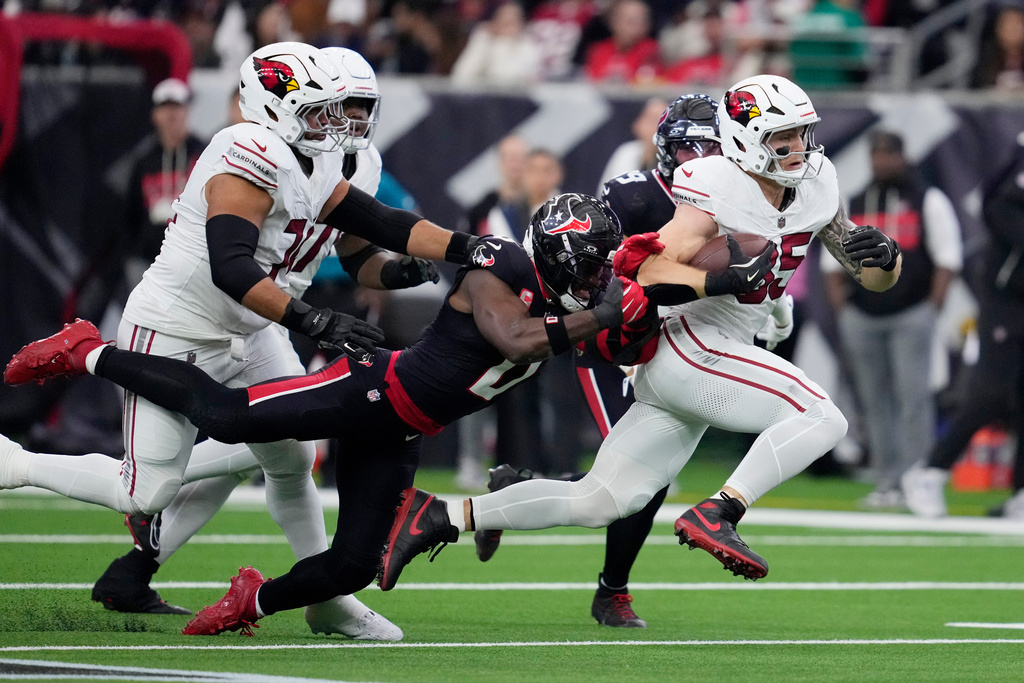 Arizona Cardinals tight end Trey McBride, right, runs with the ball as Houston Texans linebacker Azeez al-Shaair, left, tries to make a tackle during the first half of an NFL football game Sunday, Dec. 14, 2025, in Houston. (AP Photo/Ashley Landis)