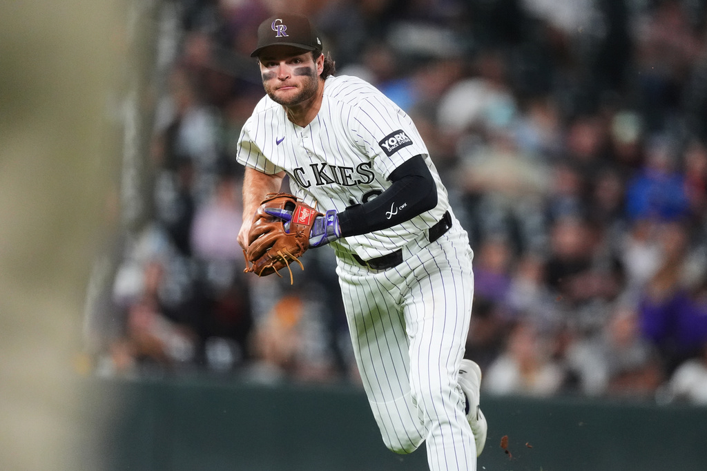 Colorado Rockies third baseman Kyle Karros throws to first base to put out San Diego Padres' Jake Cronenworth in the fifth inning of a baseball game Wednesday, Sept. 16, 2026, in Denver. (AP Photo/David Zalubowski)