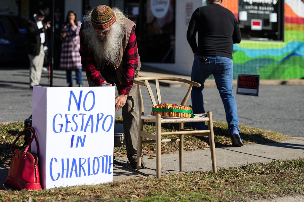 Protesters set up outside of Manolo's Bakery amidst federal law enforcement, Monday, Nov. 17, 2025, in Charlotte, N.C. (AP Photo/Matt Kelley)