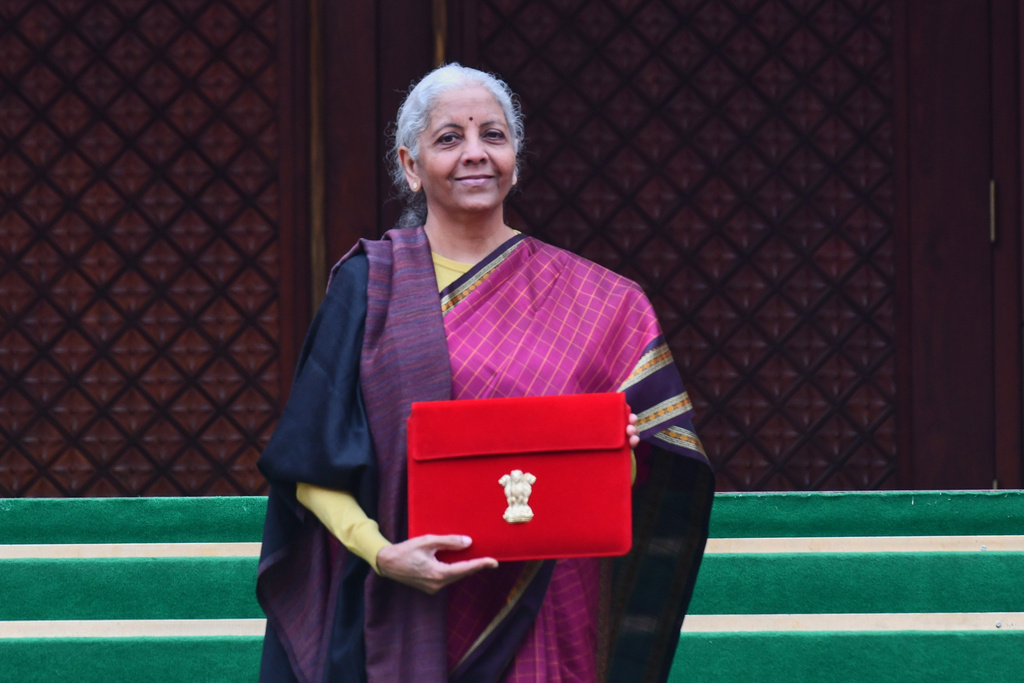 Indian Finance Minister Nirmala Sitharaman displays a red folder containing the Union Budget 2026-27 at the steps of the parliament house before tabling it, in New Delhi, India, Sunday, Feb. 1, 2026. (AP Photo)