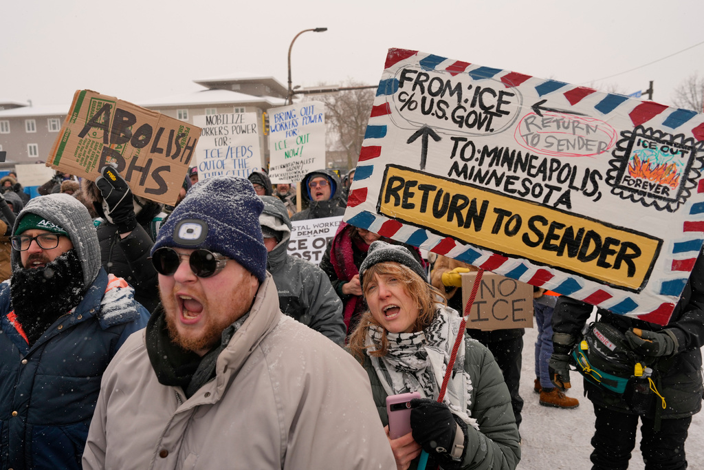 People march and gather near the post office during a protest, Sunday, Jan. 18, 2026, in Minneapolis. (AP Photo/Yuki Iwamura)