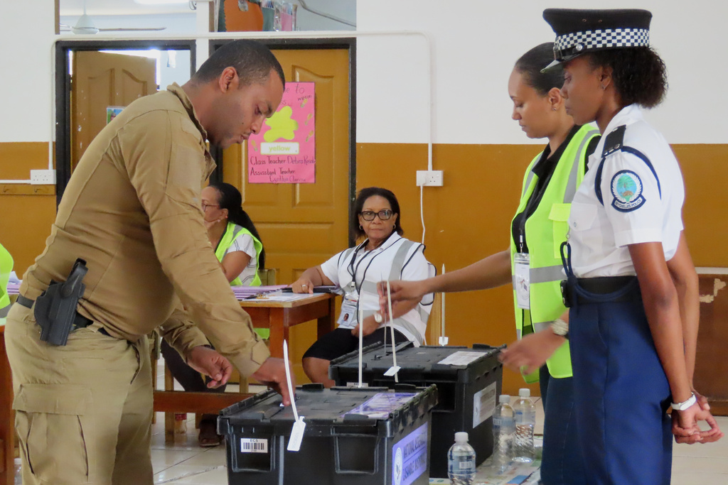 A police officer casts his vote at the English River School in Victoria, Seychelles, Thursday, Sept. 25, 2025. (AP Photo/Emilie Chetty)