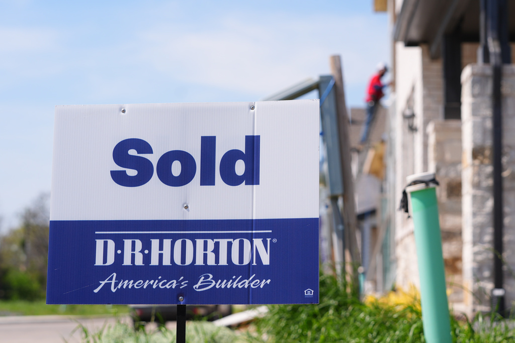 A sold sign sits on a lot for a home built by DR Horton in Richardson, Texas, Monday, March 23, 2026. (AP Photo/LM Otero)