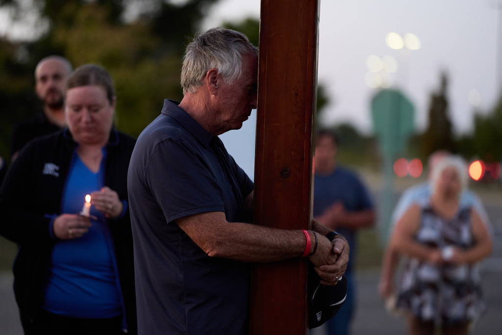 Dan Beazley, of Northville, prays during a vigil held at the Henry Ford Genesys Regional Hospital for the Sunday morning shooting at The Church of Jesus Christ of Latter-day Saints in Grand Blanc Township, Mich., Tuesday, Sept. 30, 2025. (AP Photo/Ryan Sun)