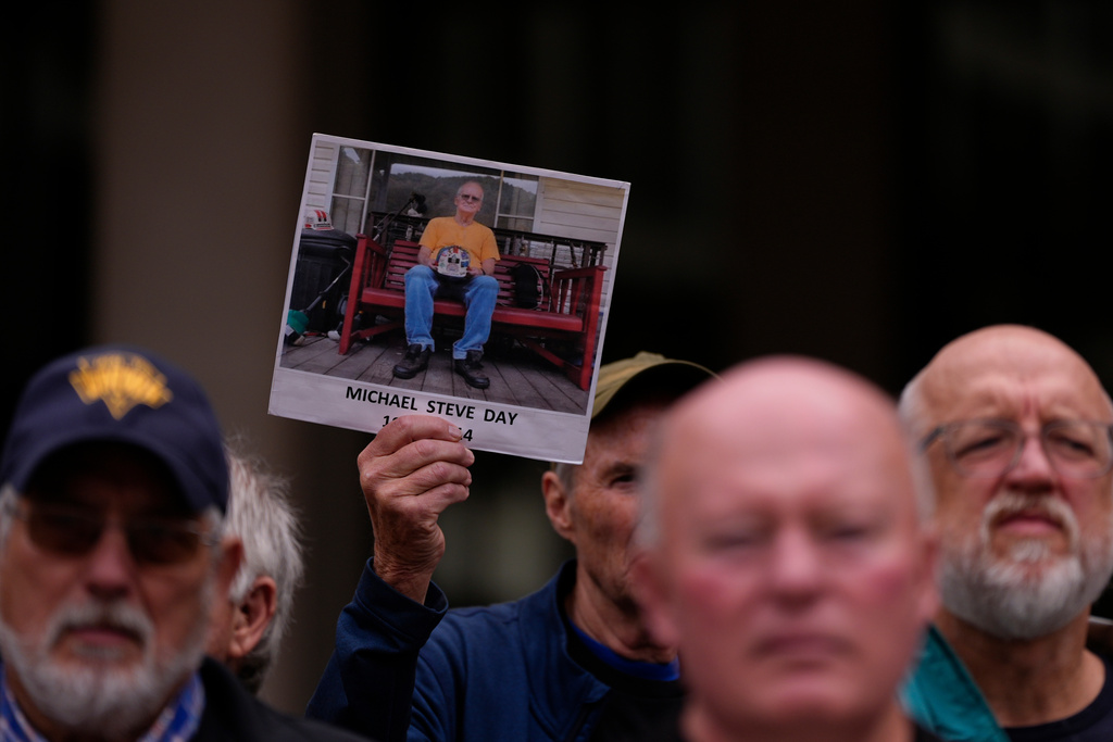 A man holds an image of Michael Steve Day Sr., a West Virginia coal miner who died of black lung disease in 2014, during a protest outside the U.S. Department of Labor, Oct. 14, 2025, in Washington. (AP Photo/Carolyn Kaster)