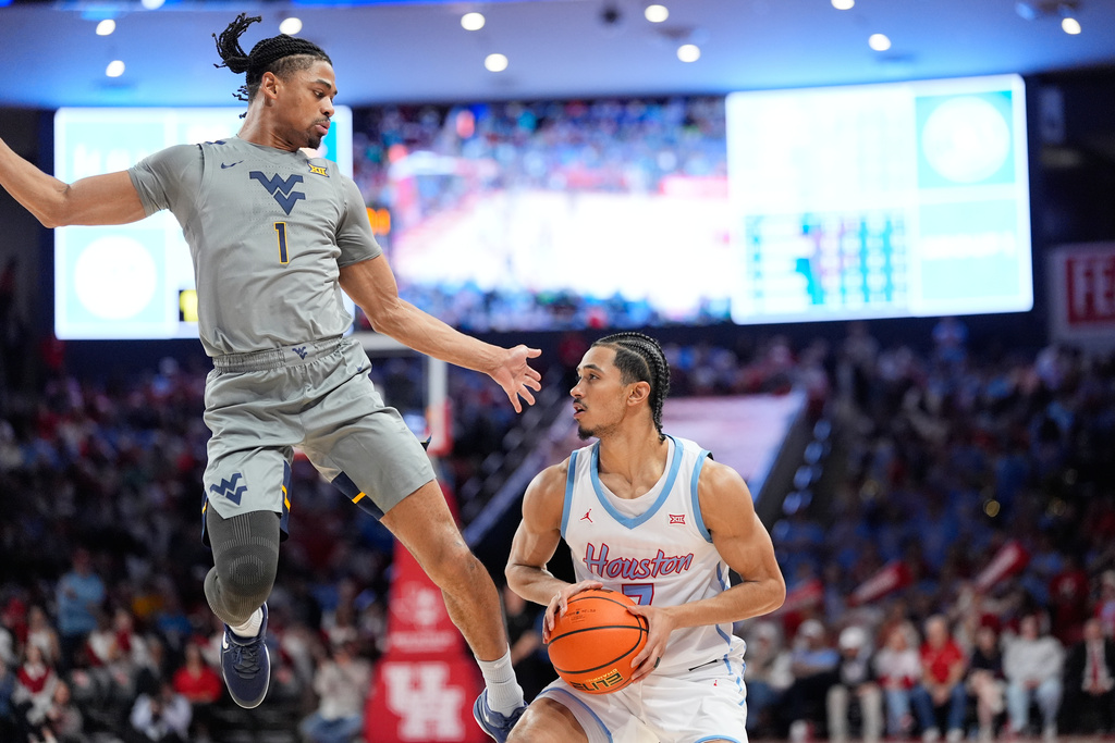 West Virginia's Jasper Floyd (1) defends against Houston's Milos Uzan during the second half of an NCAA college basketball game Tuesday, Jan. 13, 2026, in Houston. (AP Photo/David J. Phillip)