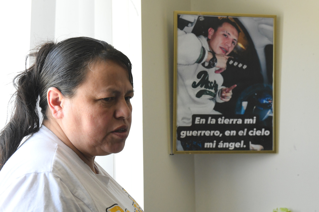 Adriana Garzon, mother of Brayan Rayo Garzon who died by suicide while in ICE custody in April 2025, stands next to a photo of Rayo that reads "On earth, my warrior; in heaven, my angel" in Spanish in Garzon's home in St. Louis, Friday, May 1, 2026. (AP Photo/Nick Ingram)