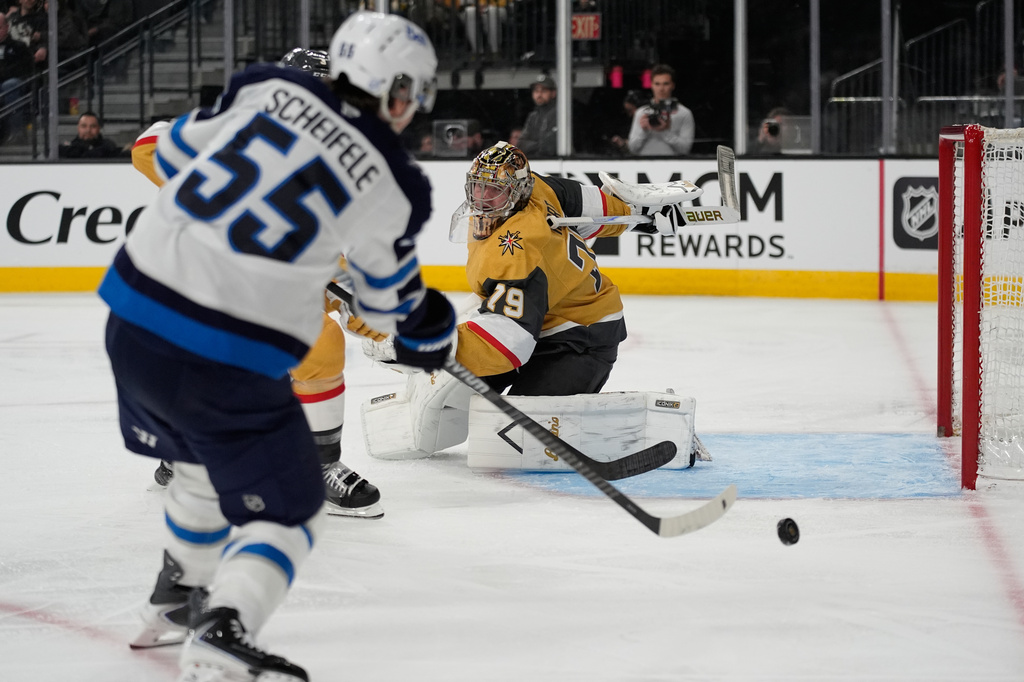 Winnipeg Jets center Mark Scheifele (55) scores against Vegas Golden Knights goaltender Carter Hart (79) during the third period of an NHL hockey game Monday, April 13, 2026, in Las Vegas. (AP Photo/John Locher)