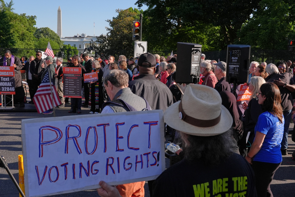 FILE - A person holds a sign about protecting voting rights during a protest near the White House, May 11, 2026, in Washington. (AP Photo/Jacquelyn Martin, File)