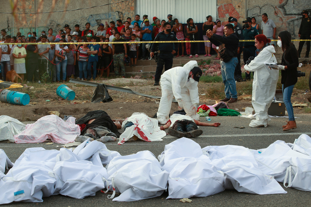 FILE - Bodies in bags sit on the side of the road after a deadly semi-trailer truck crash in Tuxtla Gutierrez, Chiapas state, Mexico, Dec. 9, 2021. (AP Photo, File)
