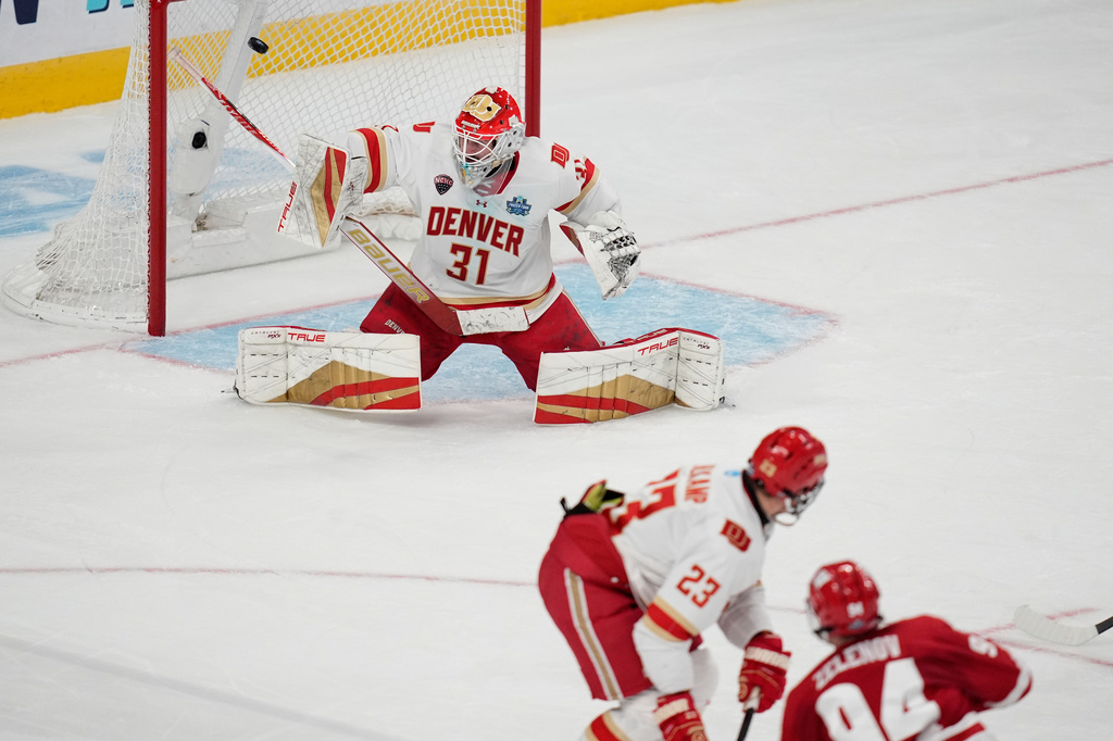 Wisconsin forward Vasily Zelenov (94) scores on Denver goaltender Johnny Hicks (31) in the first period of the championship game at the NCAA Frozen Four men's college hockey tournament Saturday, April 11, 2026, in Las Vegas. (AP Photo/John Locher)