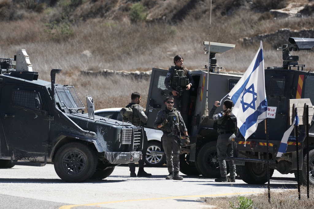 Members of the Israeli forces stand guard near the site of a shooting attack that, according to Israeli officials, killed one Israeli near the settlement of Neve Tzuf, north of the West Bank city of Ramallah, Sunday, Sept. 20, 2026. (AP Photo/Mahmoud Illean)