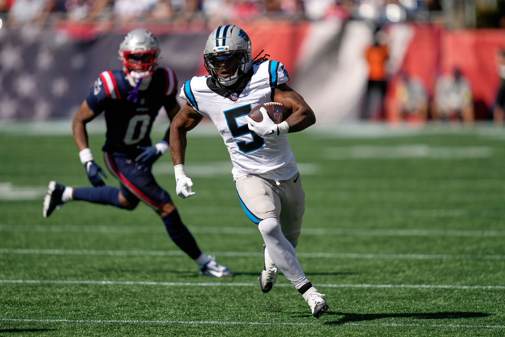 Carolina Panthers running back Rico Dowdle (5) runs against New England Patriots cornerback Christian Gonzalez (0) during the first half of an NFL football game, Sunday, Sept. 28, 2025, in Foxborough, Mass. (AP Photo/Charles Krupa)