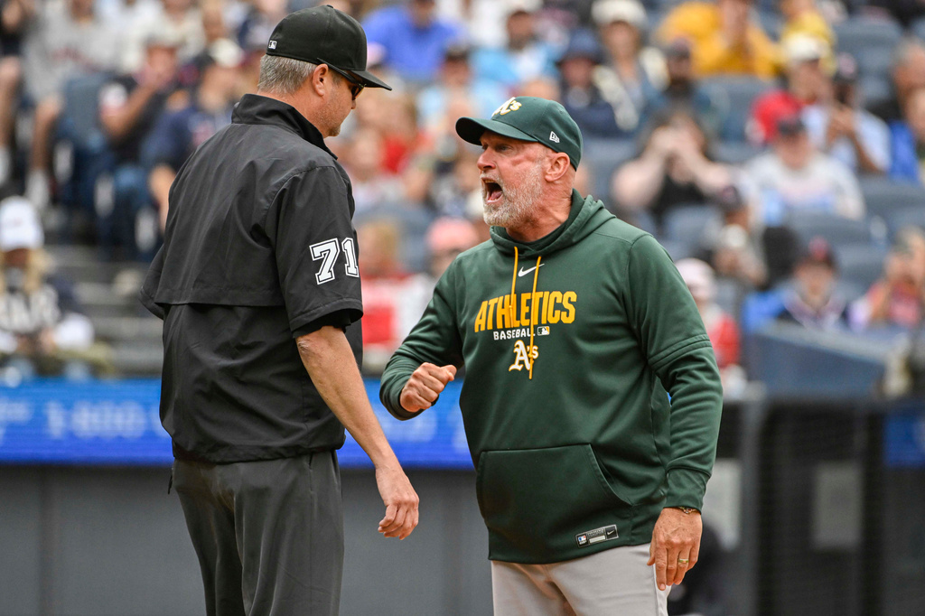 Athletics manager Mark Kotsay, right, argues a call at first base with umpire Jordan Baker, left, during the fourth inning of a baseball game against the Cleveland Guardians, Sunday, Sept. 20, 2026, in Cleveland. (AP Photo/Phil Long)