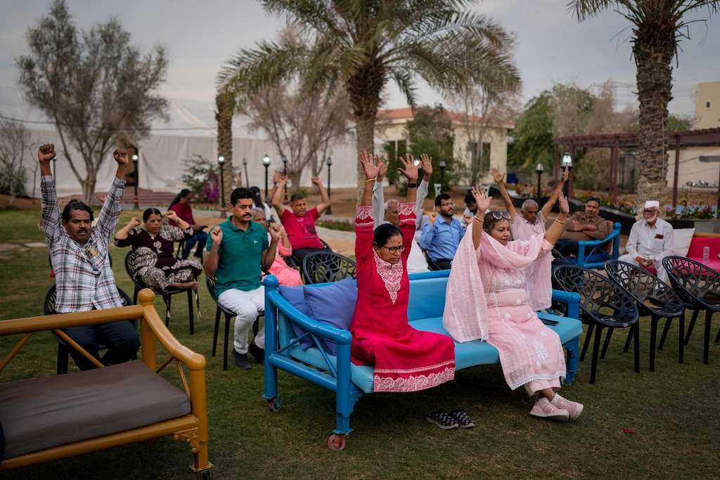 Stranded Indian travelers participate in a yoga session at a farmhouse owned by an Indian businessman, now converted into a shelter in Ajman, near Dubai, United Arab Emirates, Saturday, March 7, 2026. (AP Photo/Altaf Qadri)