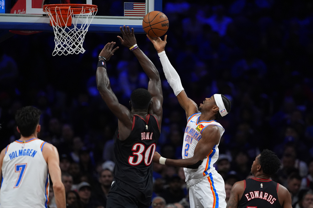 Oklahoma City Thunder's Shai Gilgeous-Alexander (2) goes up for a shot against Philadelphia 76ers' Adem Bona (30) during the first half of an NBA basketball game Monday, March 23, 2026, in Philadelphia. (AP Photo/Matt Slocum)