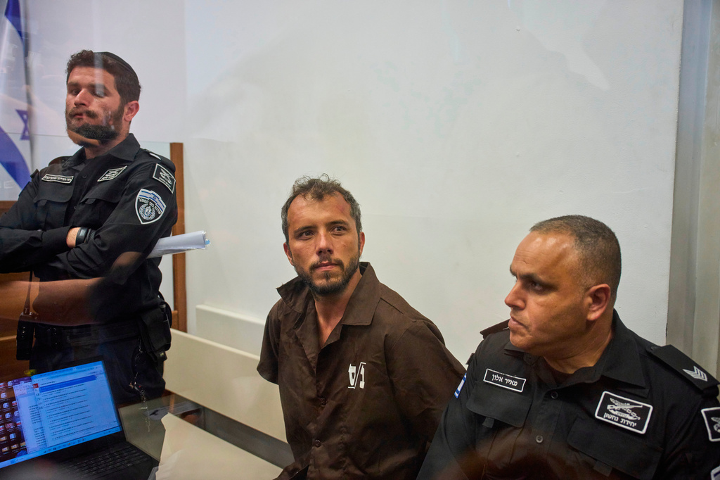 Brazilian activist Thiago Ávila, center, a member of the Global Sumud Flotilla, is escorted by prison service guards to a hearing at the District Court in Ashkelon, Israel, on Sunday, May 3, 2026. (AP Photo/Ohad Zwigenberg)