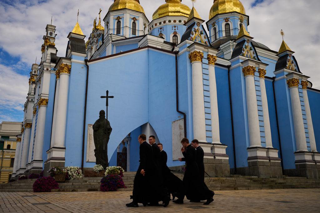 A group of young Christian Orthodox clerics walk next to St. Michael cathedral in downtown Kyiv, Ukraine, Saturday, Sept. 5, 2026. (AP Photo/Francisco Seco)