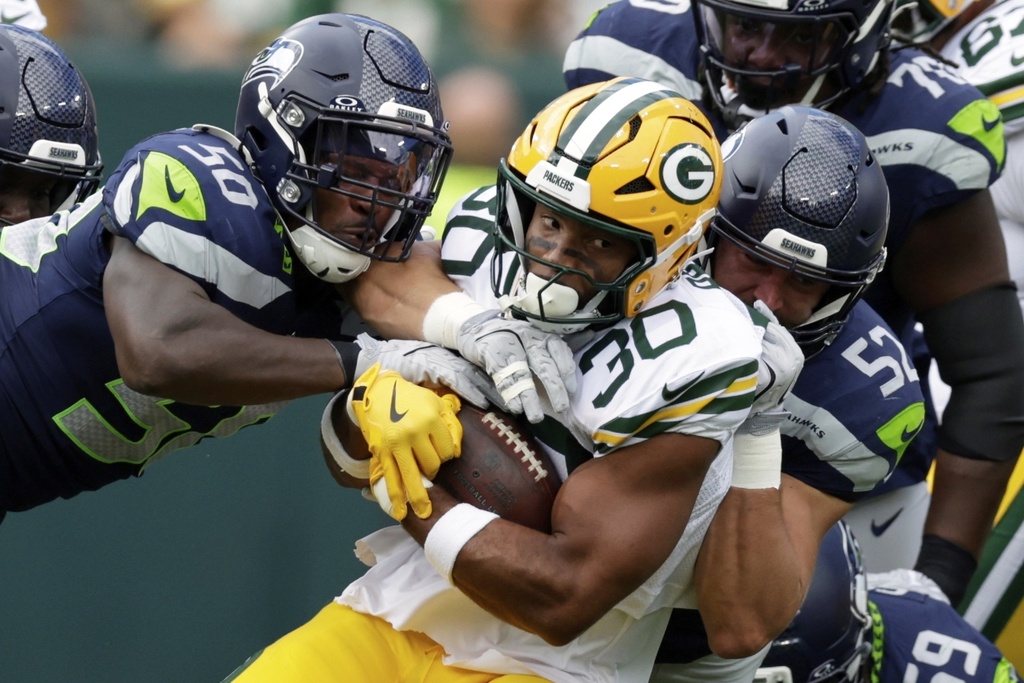 Seattle Seahawks' Jamie Sheriff and Patrick O'Connell stop Green Bay Packers' Chris Brooks during the first half of a preseason NFL football game Saturday, Aug. 23, 2025, in Green Bay, Wis. (AP Photo/Matt Ludtke)