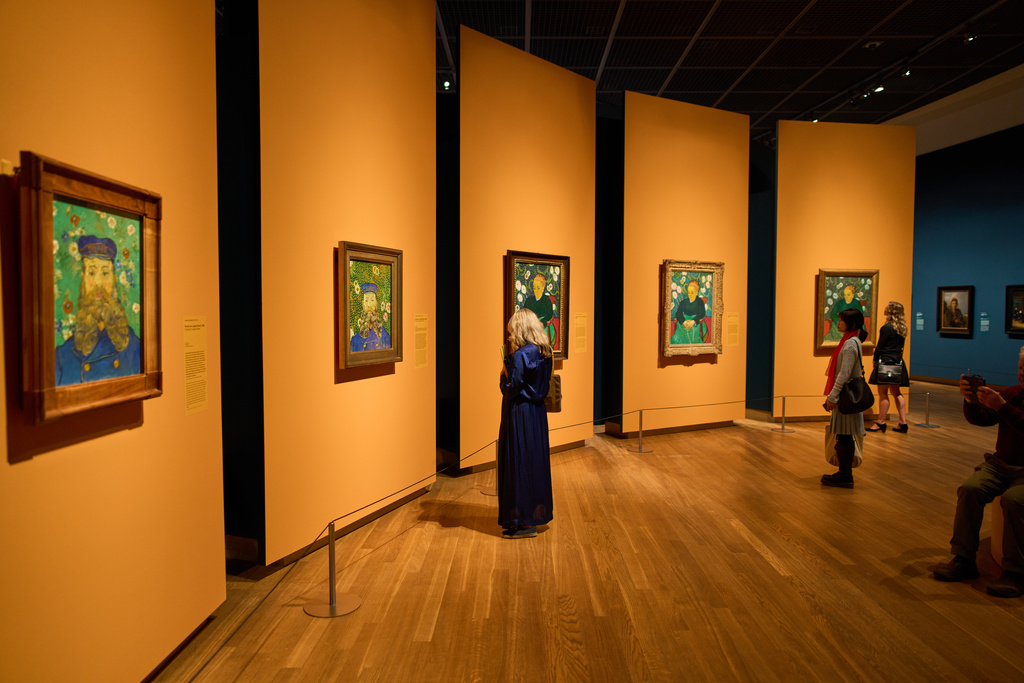 People look at portraits of the Roulin family, Jospeh, 2 paintings on the left, and his wife Augustine, 3 paintings on the right, brought together by the Van Gogh Museum in Amsterdam, Netherlands, Wednesday, Oct. 1, 2025. (AP Photo/Peter Dejong)