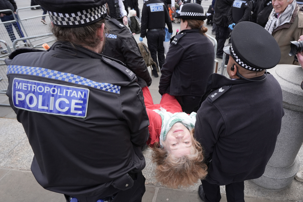 Police remove a protester at a demonstration against the ban on Palestine Action, in Trafalgar Square, central London, Saturday April 11, 2026. (Stefan Rousseau/PA via AP)