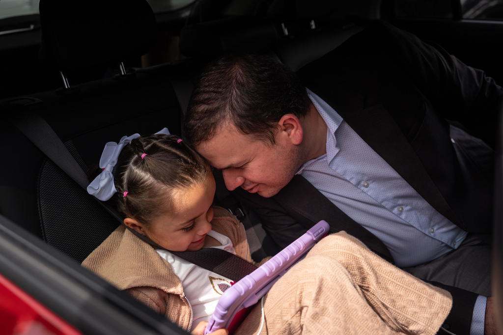 Milenko Faria, whose wife, Dr. Rubeliz Bolivar, is in immigration custody, shares a moment with their daughter, Milena, after his asylum interview at the U.S. Citizenship and Immigration Services facility in Tustin, Calif., Thursday, April 16, 2026. (AP Photo/Jae C. Hong)