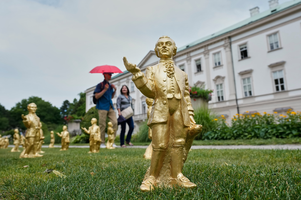FILE - People walk by some of the 400 gold colored plastic Mozart sculptures by German artist Ottmar Hoerl from Nuremberg for the 270th birthday of composer Wolfgang Amadeus Mozart in Salzburg, Austria, Wednesday, July 15, 2026. (AP Photo/Matthias Schrader, File)