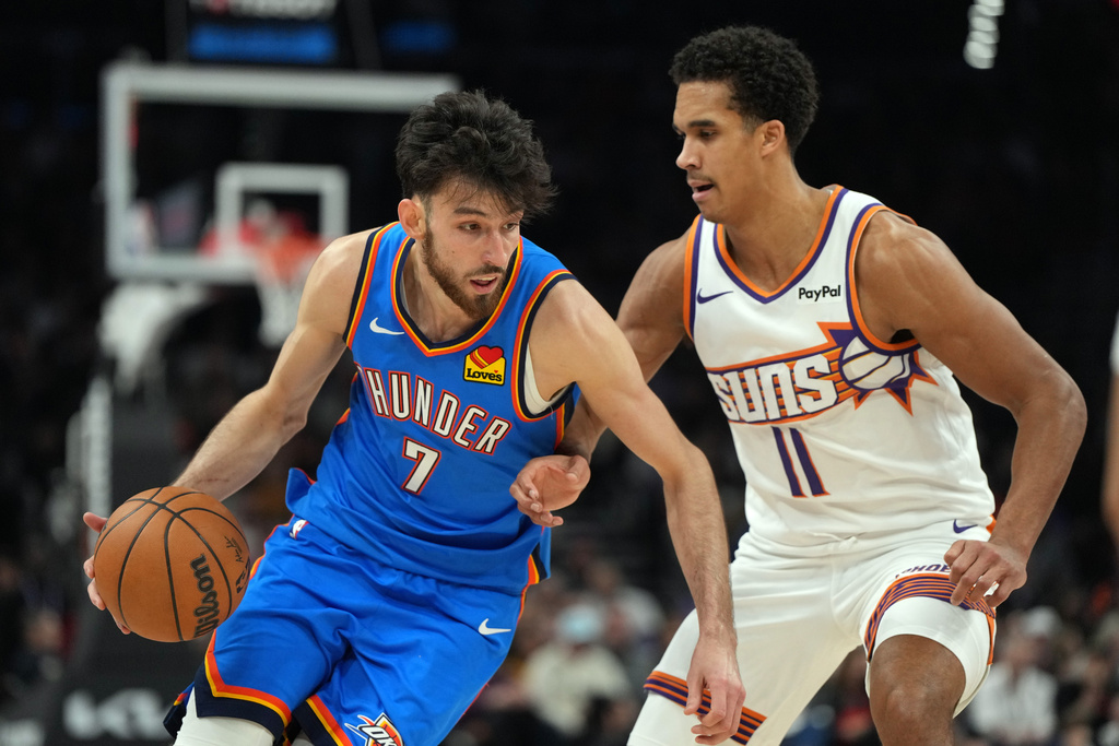 Oklahoma City Thunder center Chet Holmgren (7) drives on Phoenix Suns forward Oso Ighodaro during the first half of an NBA basketball game, Wednesday, Feb. 11, 2026, in Phoenix. (AP Photo/Rick Scuteri)